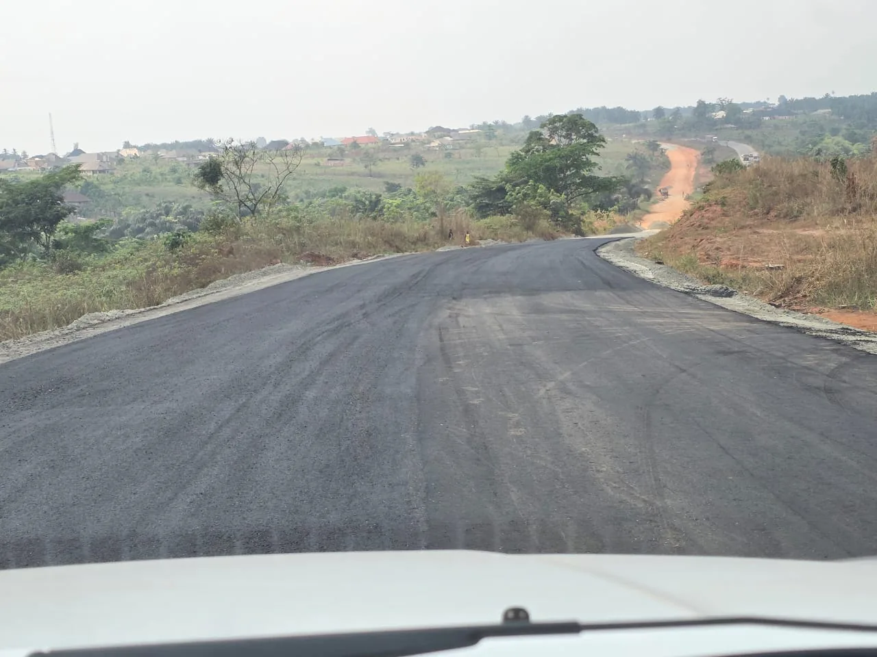 A newly surfaced section of the Benin-Asaba Expressway running towards the horizon.