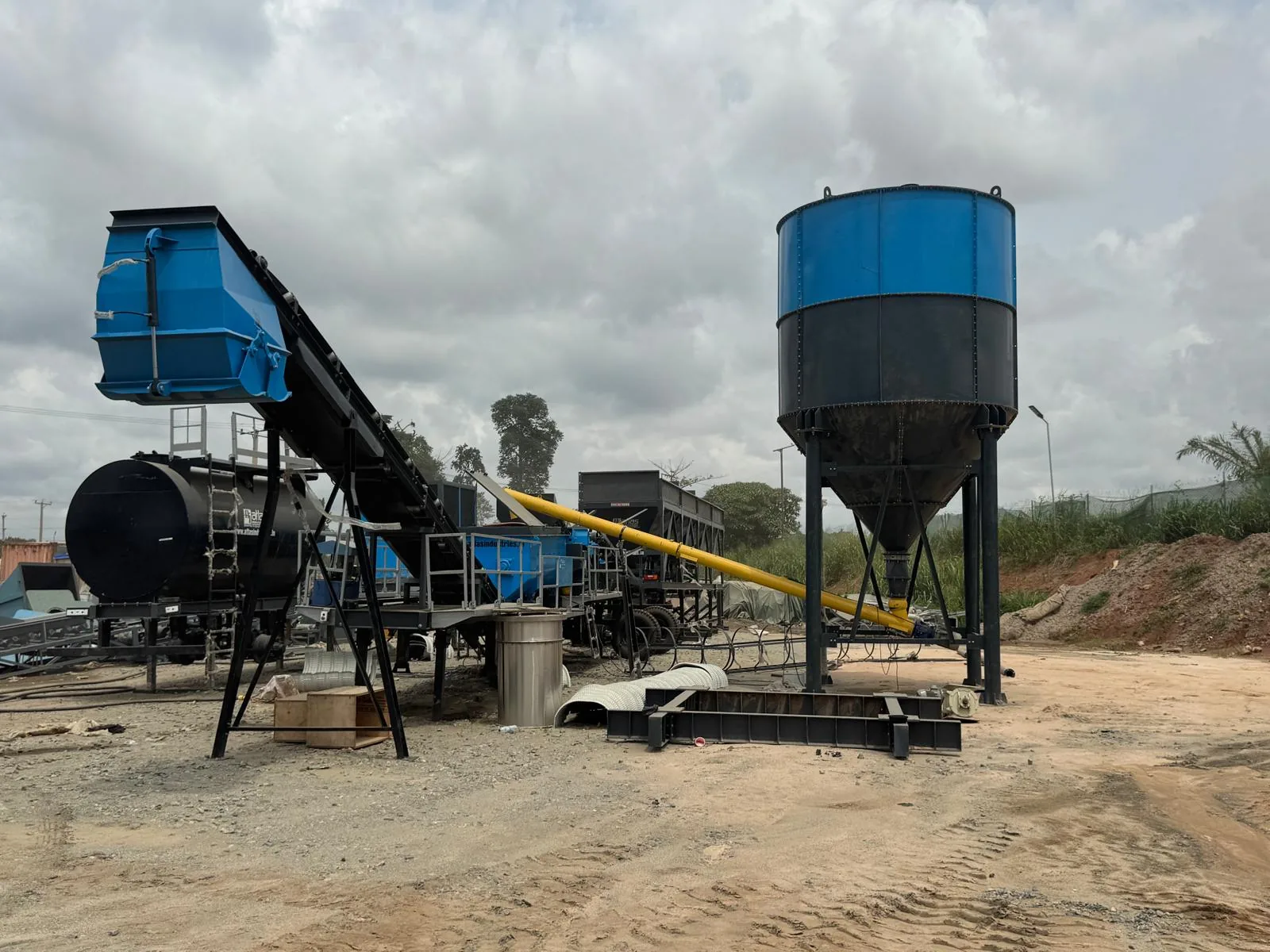 A concrete batching plant with cement silo, aggregate conveyor and screw feeder installed at the project yard.